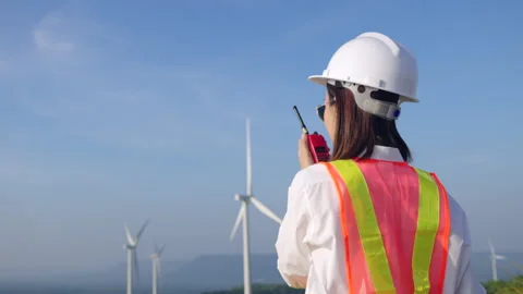 Back view of woman engineer talking to her team with radio communication. Stock Footage 251559923