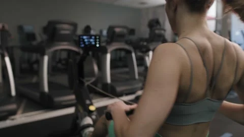 Back view of woman exercising on rowing machine Video stock 192825187