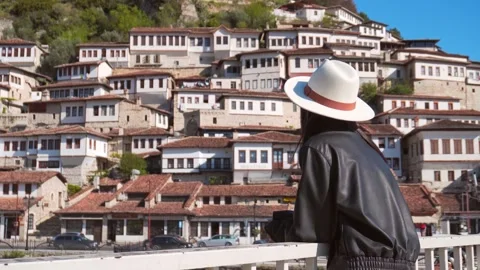 Back view woman in leather jacket lean stand on famous suspension bridge in.. Stock Footage 333119956