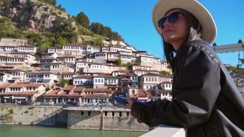 Back view woman in leather jacket lean stand on famous suspension bridge in.. Stock Footage 333294518