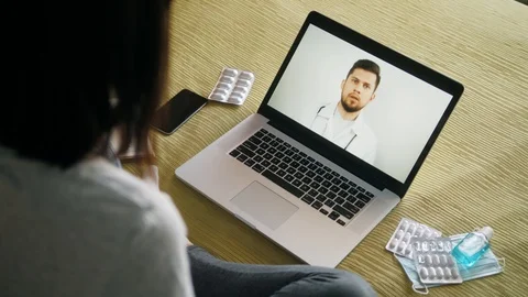 Back view of woman making video call with her doctor while staying at home Stock-Footage 129383396