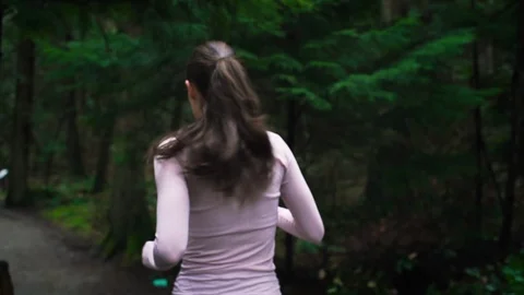 Back view of woman runner jogging on forest path. Stock Footage 95643289