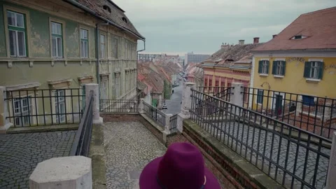 Back view of woman running down on narrow staircase in old city. Stock Footage 296549961