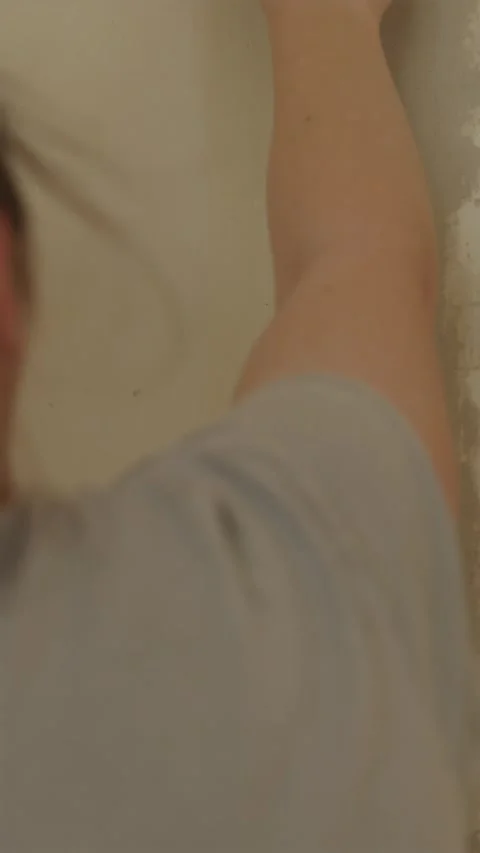 Back view of woman smoothing plaster compound on wall Vídeo Stock 340610521