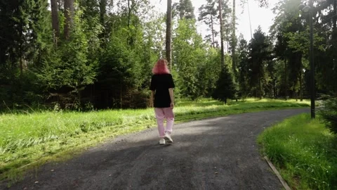 Back View of Woman Strolling Through Scenic Forest Path in Casual Clothing Stock Footage 309454555