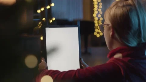 Back view of woman using digital tablet, during Christmas time. Woman talking 動画素材 201403002