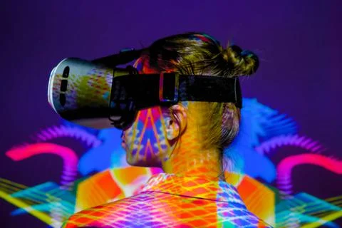 Back view: woman using virtual reality headset at dark interactive VR exhibition Foto stock