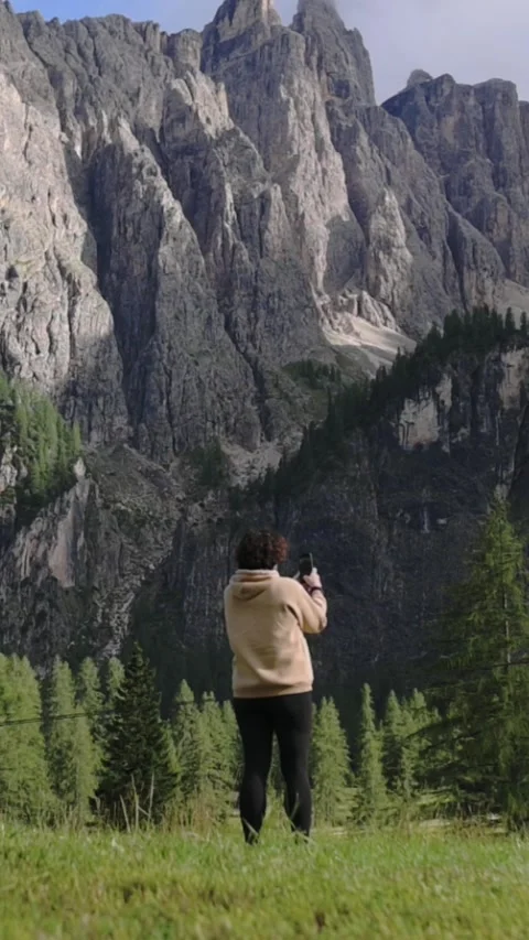 Back view of woman in vertical frame walking toward mountains Vídeo Stock 319006080