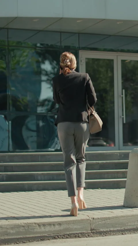 Back View Of Woman Walking To Work On Phone Call With Reflections And Railing Vídeos de archivo 319763545