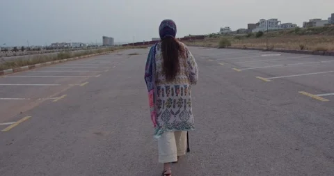 Back view of a women walking with the help of stick in a parking lot Stock Footage 137440171