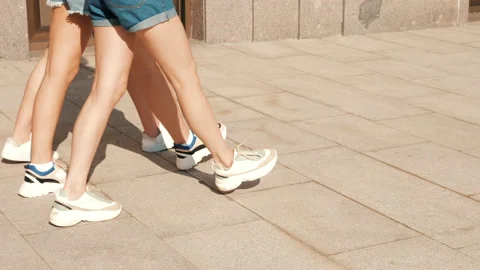 Back view of women's sexy long legs going slowly in the street Stock Footage 141786484