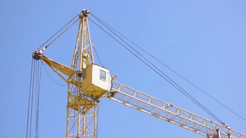 Back view of a yellow tower crane in the blue sky background. 動画素材 314852590