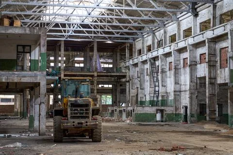 Back view of yellow wheel loader in abandoned workshop Stock Photos