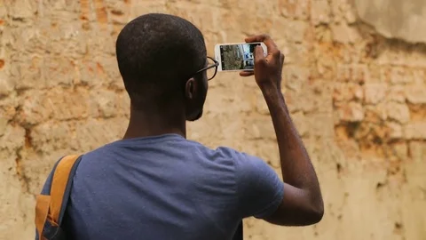 Back view of young african american man in glasses and T-shirt standing in city Stock Footage 77284962