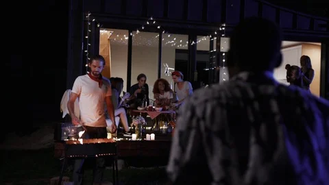 Back view of young Afro-American man in flowered shirt entering the party, gives Stock Footage 91921416