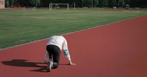 Back view of a young athlete getting ready for the race and starting to run.  動画素材 135337372