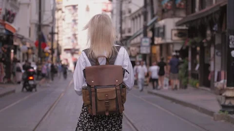 Back view Young beautiful slender woman in white shirt and leather backpack Stock Footage 252912495