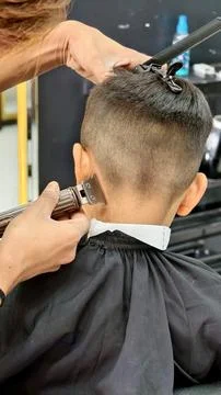 Back view of a young boy getting a professional haircut at a barbershop Stock Photos