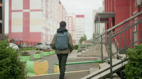 Back View of Young Boy Walking Towards Bench Holding Book Видео 318857495