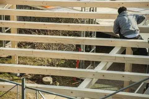 Back view of young carpenter building a carport. Stock Photos
