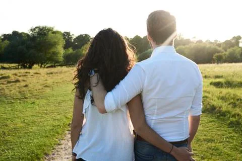Back view of young couple arm in arm at sunset Stock-Fotos