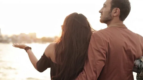 Back view of young couple enjoys a sunset on the deck of cruise boat Stock Footage 73630606