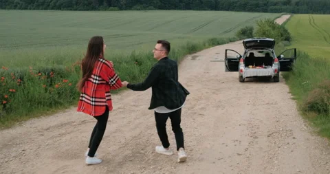 Back View of Young Couple Having Fun on a Road Trip, Girl with Her Boyfriend Stock Footage 154459944
