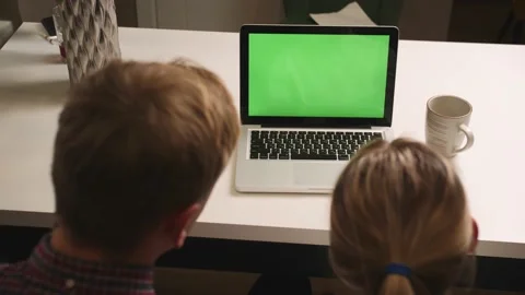 Back view: Young couple man and woman using laptop with green screen chromakey Stock Footage 146600332