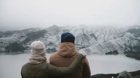Back view of young couple standing in Ice lagoon. Traveling man and woman Stock Footage 82976542