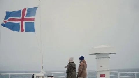 Back view of young couple standing on the board of the ship, close to Icelandic Stock Footage 82998795
