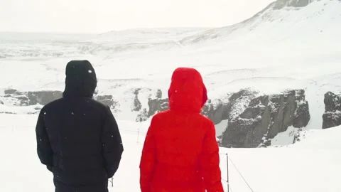 Back view of young couple walking in winter mountain together in Iceland Stock Footage 135190631
