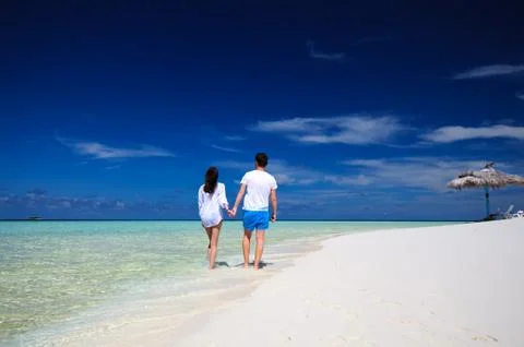 Back view of young couple on white beach. Vacation concept Stock Photos