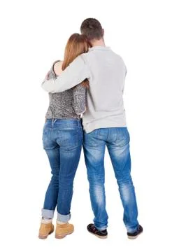Back view of young embracing couple (man and woman) hug and look Stock Photos