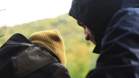 Back view of young father using smartphone with little son boy resting outside Vidéo 218258243