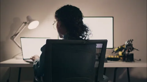 Back view of a young female programmer coding late at night. Video stock 319001150