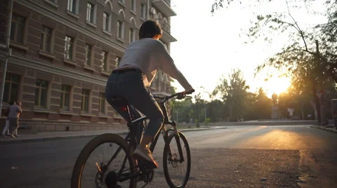 Back view young female rides a bike in morning city Stock Footage 68346064