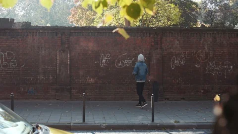 Back view of young graffiti painter in casual outfit looking at his work Stock Footage 105243581