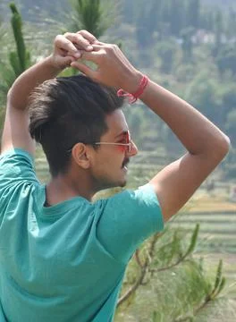Back view of a young guy wearing sunglass and posing in outdoor  Stock Photos
