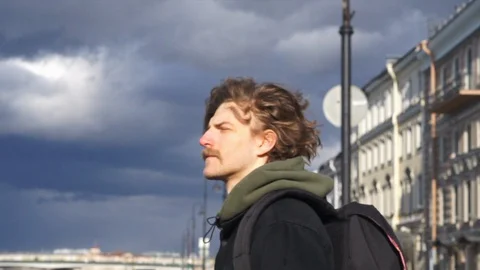 Back view on young male with backpack walks along the river Stock Footage 128143089