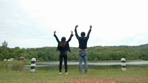 Back view of  Young man and woman walking holding hands enjoying Stock Footage 114493241
