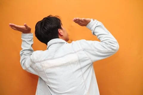 Back view of Young man gesture carry on head feel heavy isolated on yellow .. Stock Photos