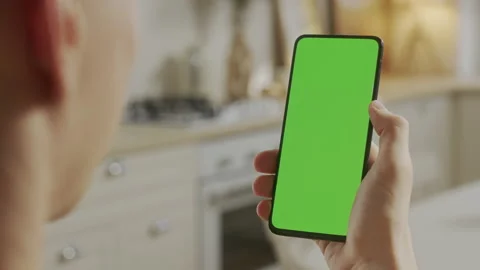 Back View of Young Man at Home Sitting on Kitchen Room using With Green Mock-up Stock Footage 170764125