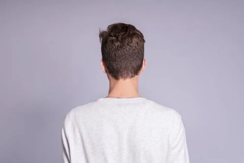 Back view of young man over gray background. Stock Photos