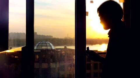 Back view of young man sitting on window with coffee cup, has a breakfast Stock Footage 68529764