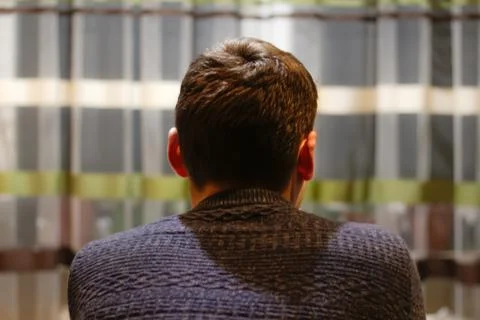 Back view of young man sitting home and thinking. Lost in thoughts, thinking Stock Photos