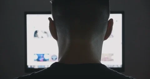 Back view of young man surfing internet at night Vídeos de archivo 95507488