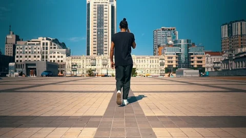 Back view young man talking by phone on the run outdoors Stock Footage 127848824