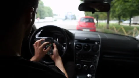 Back View of Young Man Using Phone Inside Car on Driver Seat. Stock Footage 109604957