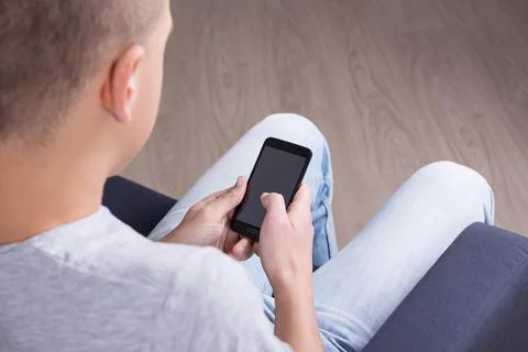 Back view of young man using smart phone Stock Photos