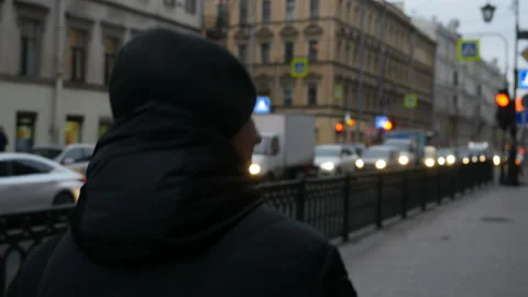 Back view  of young man walking down the city street and drinking coffee Stock Footage 104901384
